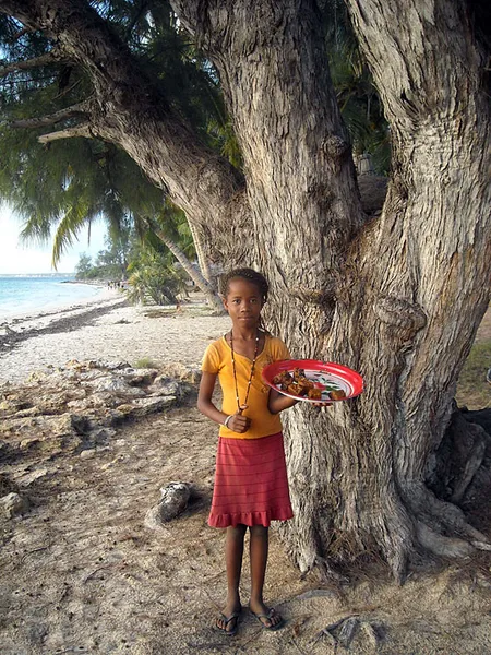  Young girl and plate of doughnut under a filao tree