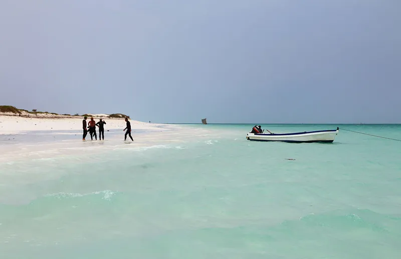 Plongeurs sur la plage, et leur bateau